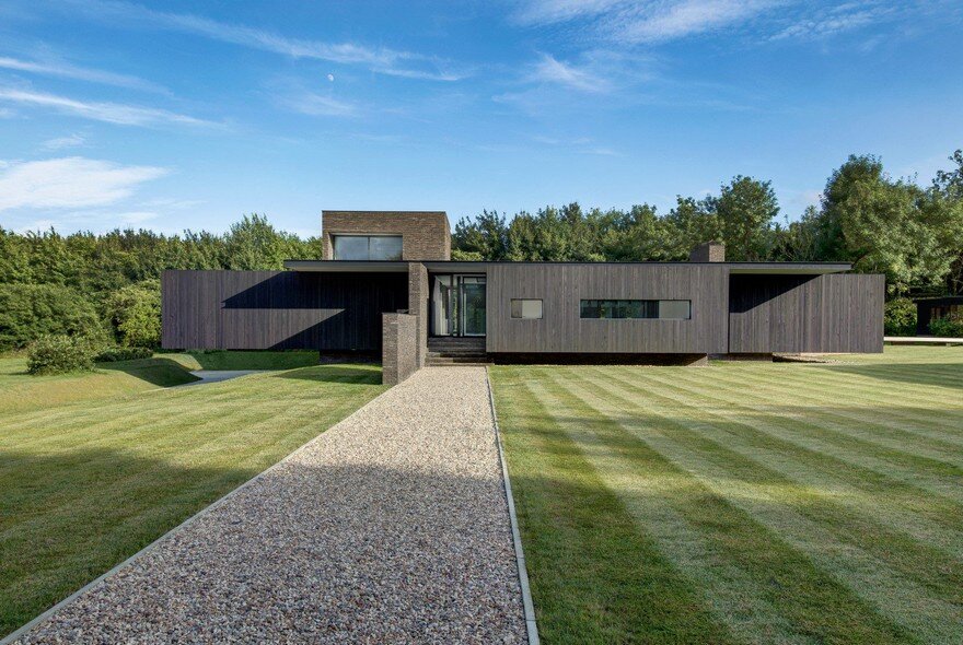 Black Modern House Consisting of Five Modules Clustered Around a Central Courtyard