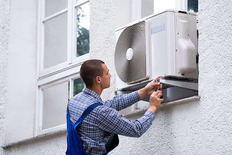 Technician Cleaning And Repairing Air Condition Appliance. AC Unit Maintenance